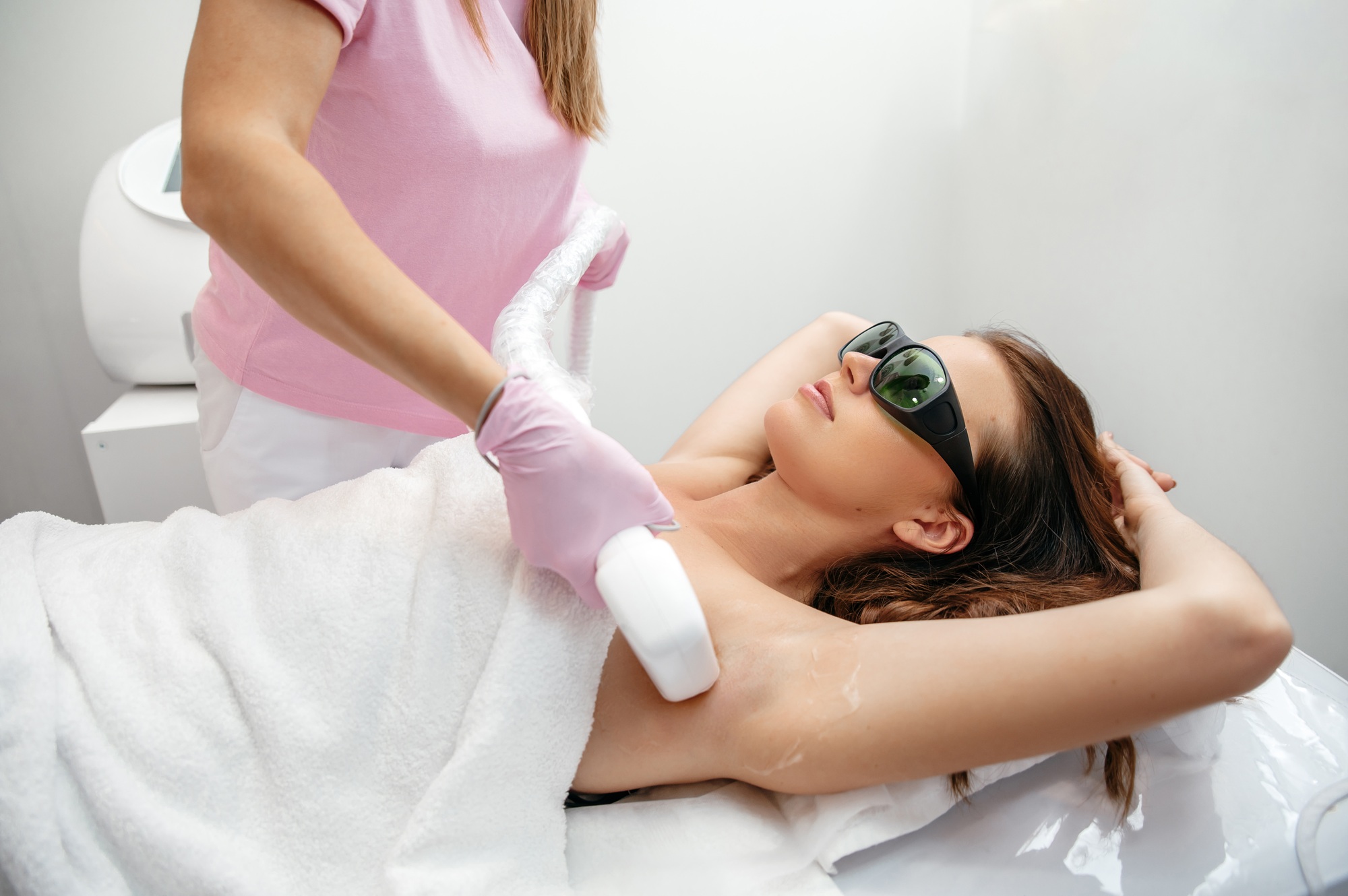 Inicio 2 Hair removal by laser hair removal. Caucasian young woman lies on the couch with protective glasses